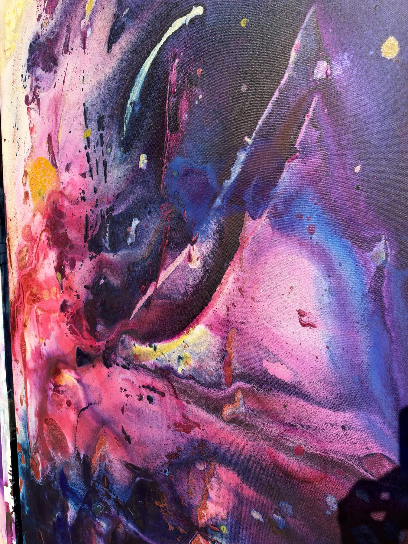 Close detail of dark purple and magenta paint with splatter, drips and a curved pale stroke.