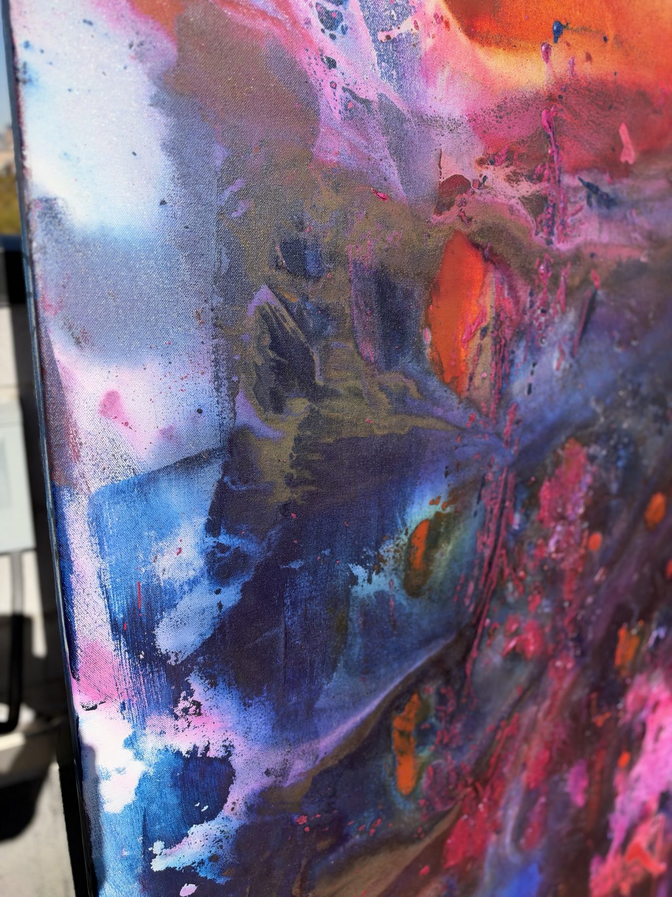 Close detail of a lower edge, blue and grey washes against orange and pink marks.