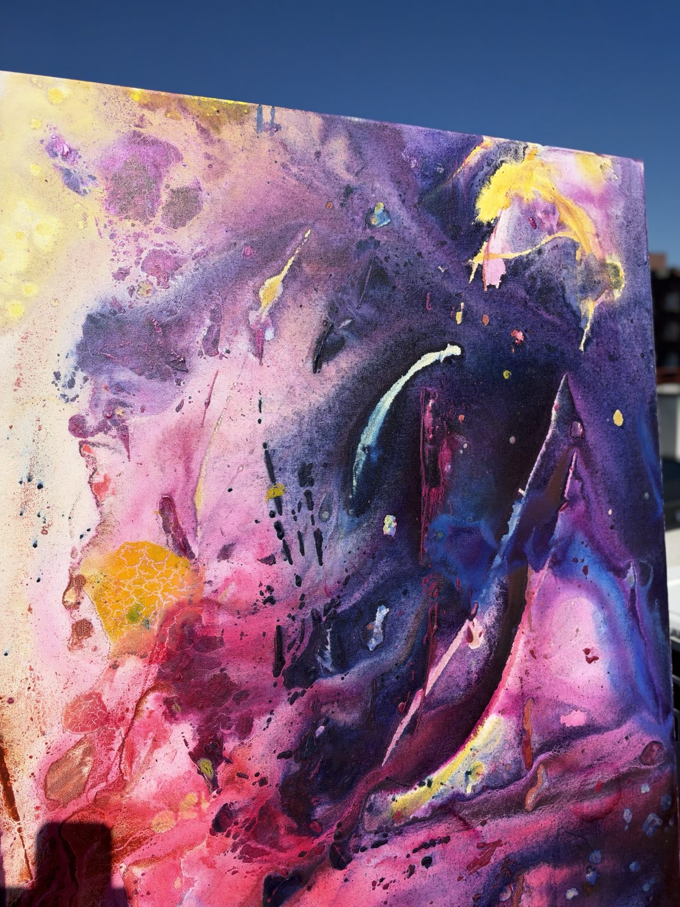 Close detail of a top corner, yellow fading into pink and deep purple with a blue cut.